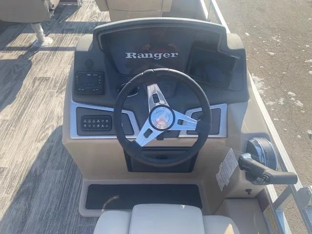Slide: The Image of 2024 Ranger Reata 220F boat dashboard with steering wheel and controls. - 2