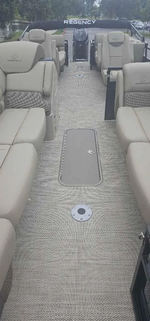 Slide: The Image of 2024 Regency 250 LE3 pontoon boat with luxurious beige seating and spacious deck. - 3