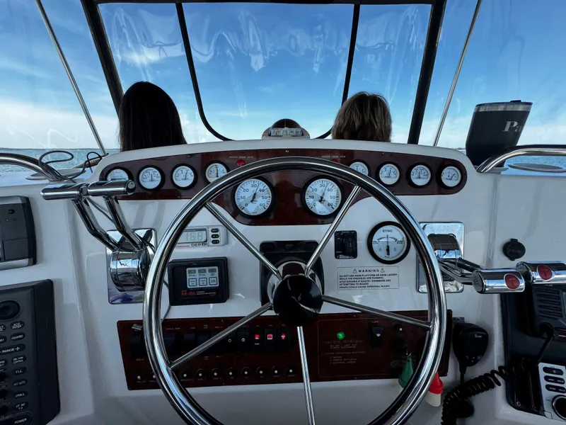 Slide: The Image of 1999 Silverton 392 Motor Yacht helm with steering wheel and instrument panel. - 11