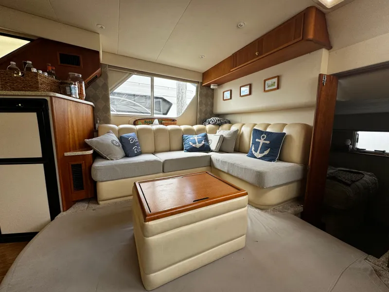 Slide: The Image of 1999 Silverton 392 Motor Yacht interior with cozy seating and nautical decor. - 14