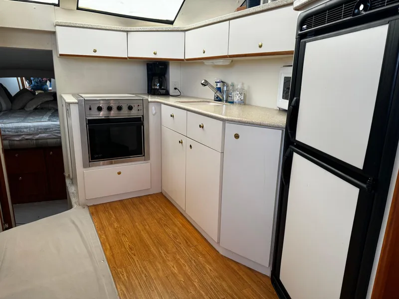Slide: The Image of 1999 Silverton 392 Motor Yacht kitchen with stove, refrigerator, and ample storage. - 15