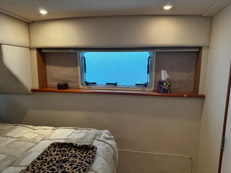 Slide: The Image of Interior cabin of 1999 Silverton 392 Motor Yacht with window and bed. - 23