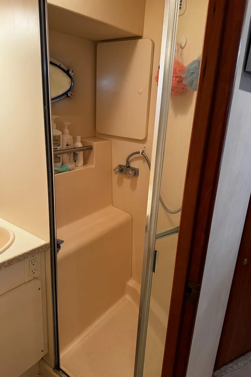 Slide: The Image of 1999 Silverton 392 Motor Yacht bathroom with shower and storage. - 25