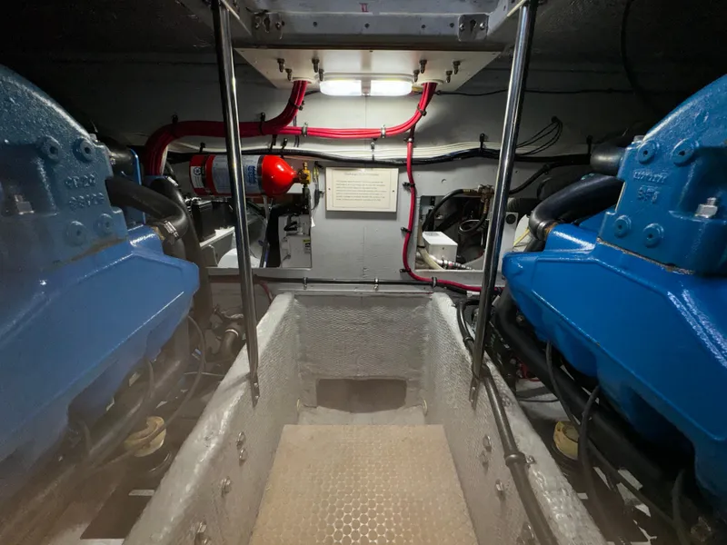 Slide: The Image of Engine room of a 1999 Silverton 392 Motor Yacht with blue engines and red wiring. - 27