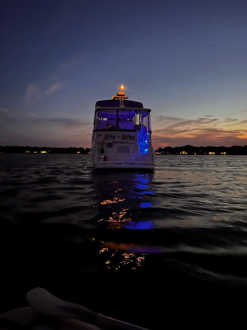 Slide: The Image of 1999 Silverton 392 Motor Yacht illuminated at dusk on calm waters. - 39