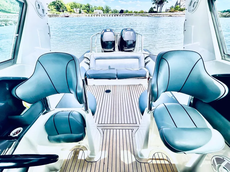 Slide: The Image of Interior of 2005 Protector 28 Targa boat with blue seating and wooden deck. - 2