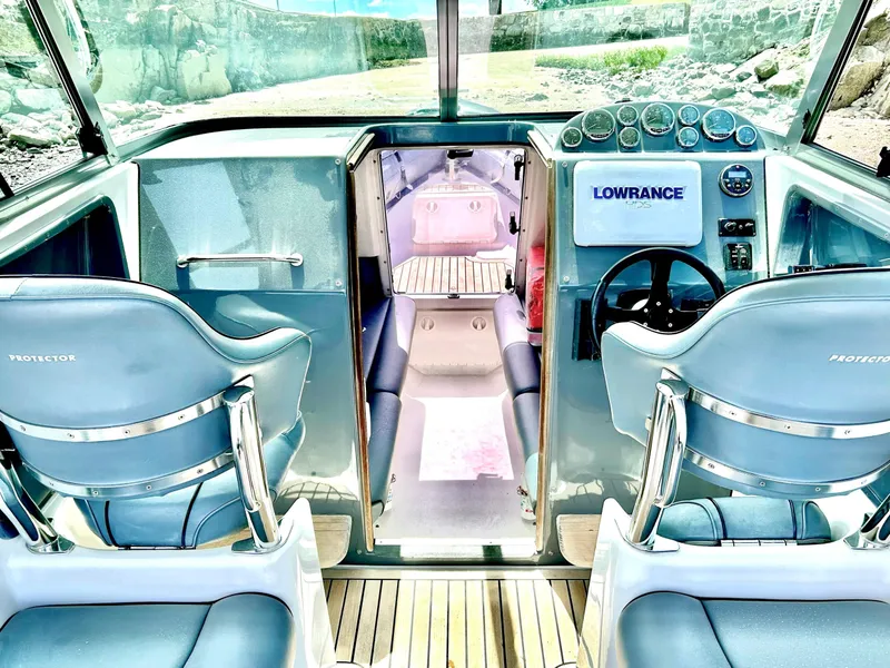 Slide: The Image of Interior of 2005 Protector 28 Targa boat with blue seating and navigation equipment. - 3
