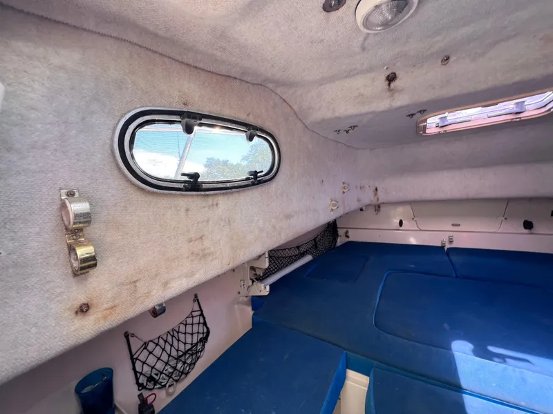 Slide: The Image of 1998 Grady-White F-26 Tigercat cabin interior with blue cushions and side window. - 10