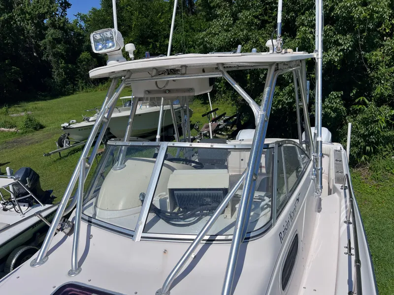 Slide: The Image of 1998 Grady-White F-26 Tigercat boat with T-top and windshield, docked on grass. - 25