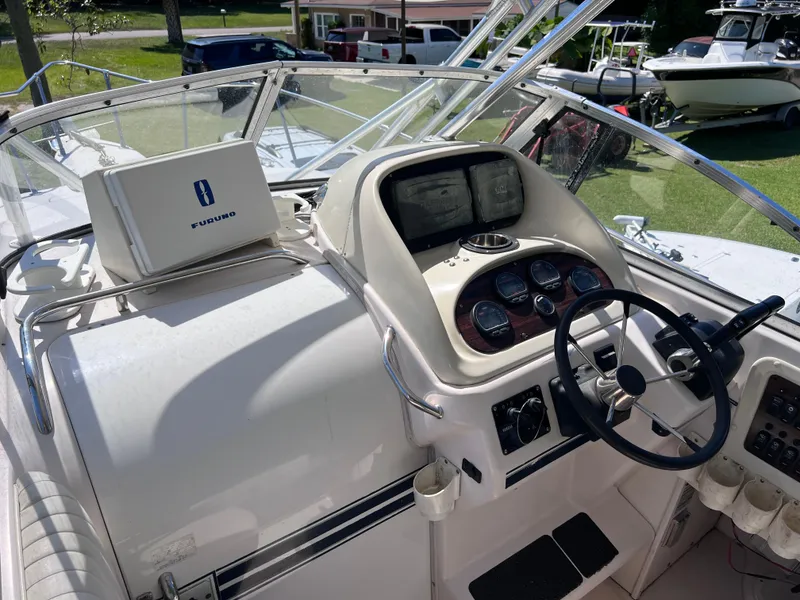Slide: The Image of 1998 Grady-White F-26 Tigercat boat dashboard with steering wheel and navigation instruments. - 30