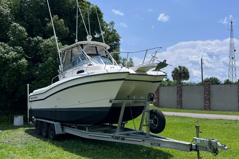 Slide: The Image of 1998 Grady-White F-26 Tigercat boat on a trailer in a grassy area. - 33