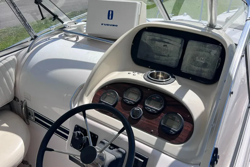 Slide: The Image of 1998 Grady-White F-26 Tigercat boat dashboard with steering wheel and navigation instruments. - 35