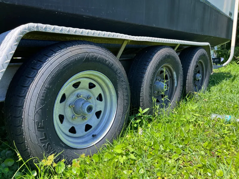 Slide: The Image of Trailer wheels of a 1998 Grady-White F-26 Tigercat boat on grass. - 7