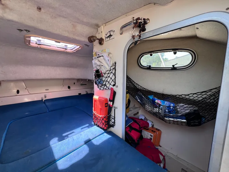 Slide: The Image of 1998 Grady-White F-26 Tigercat cabin interior with blue cushions and storage nets. - 9