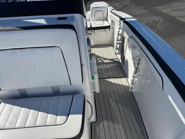 Slide: The Image of 2024 Yamaha Boats 255 FSH Sport H interior with white seating and deck. - 12