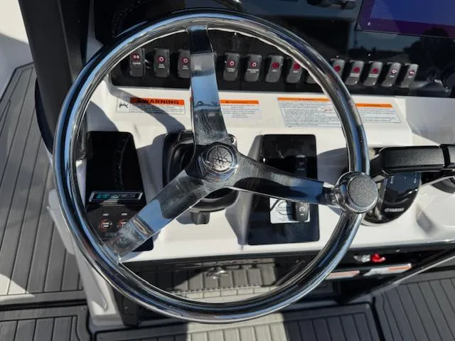 Slide: The Image of 2024 Yamaha Boats 255 FSH Sport H steering wheel and control panel. - 15