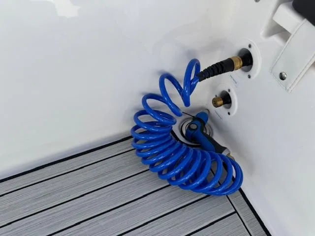 Slide: The Image of Blue coiled hose on 2024 Yamaha 255 FSH Sport H boat deck. - 22