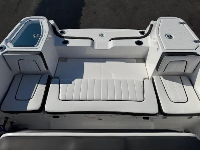 Slide: The Image of 2024 Yamaha Boats 255 FSH Sport H interior seating area, featuring sleek white upholstery. - 23