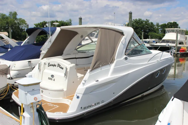 Slide: The Image of 2013 Rinker 31 boat docked at a marina on a sunny day. - 0