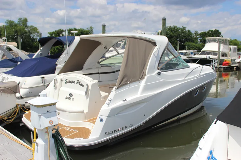 Slide: The Image of 2013 Rinker 31 boat docked at a marina on a sunny day. - 1