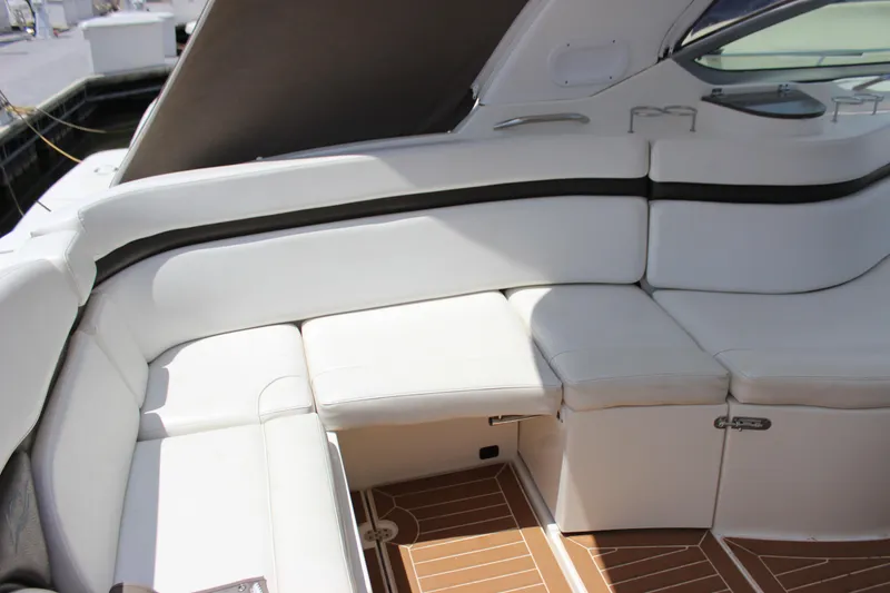Slide: The Image of 2013 Rinker 31 boat interior with white leather seating and wood flooring. - 10