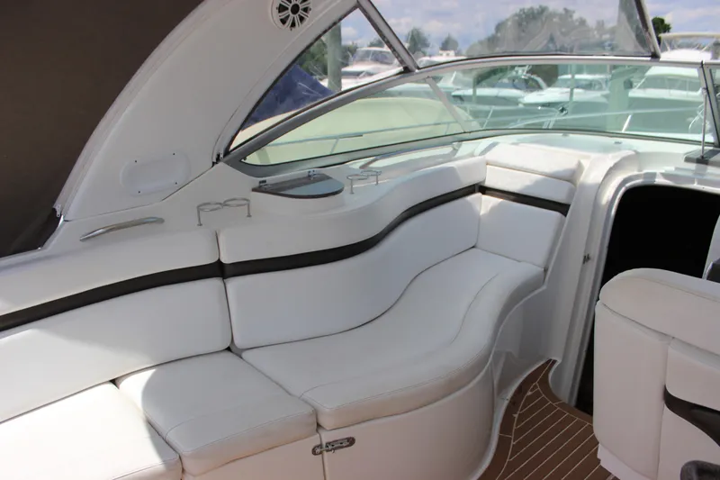 Slide: The Image of 2013 Rinker 31 boat interior with white leather seating and wood flooring. - 11