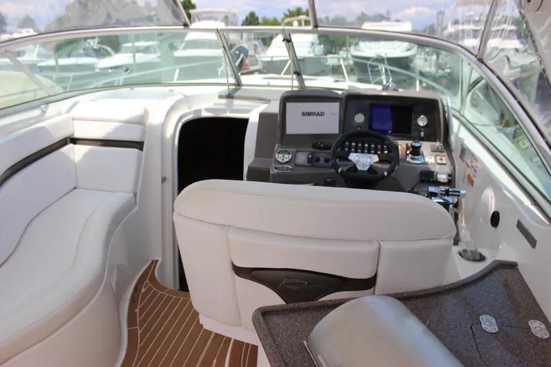 Slide: The Image of 2013 Rinker 31 boat cockpit with modern navigation system and white seating. - 14