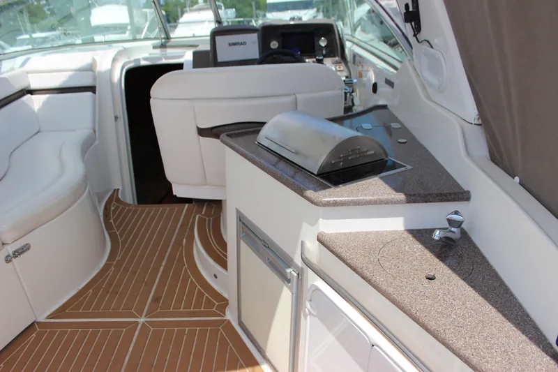 Slide: The Image of Interior of a 2013 Rinker 31 boat with seating and kitchenette. - 15
