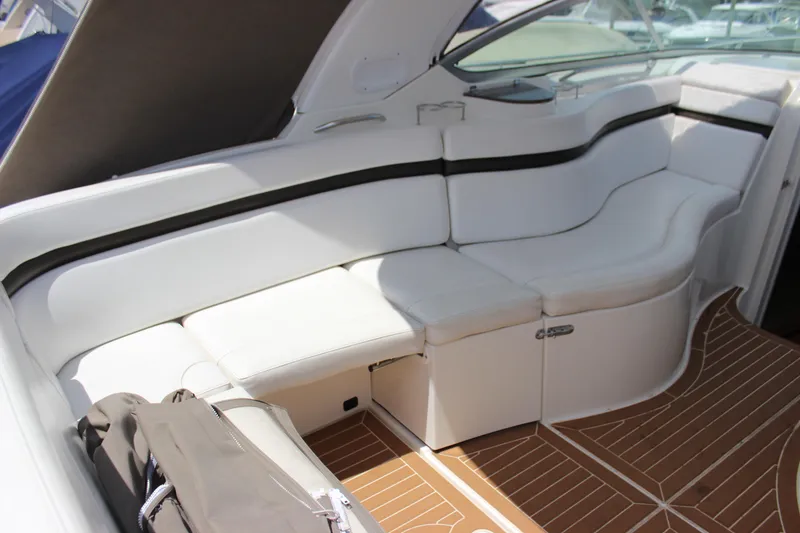 Slide: The Image of 2013 Rinker 31 boat interior with white leather seating and wooden flooring. - 18