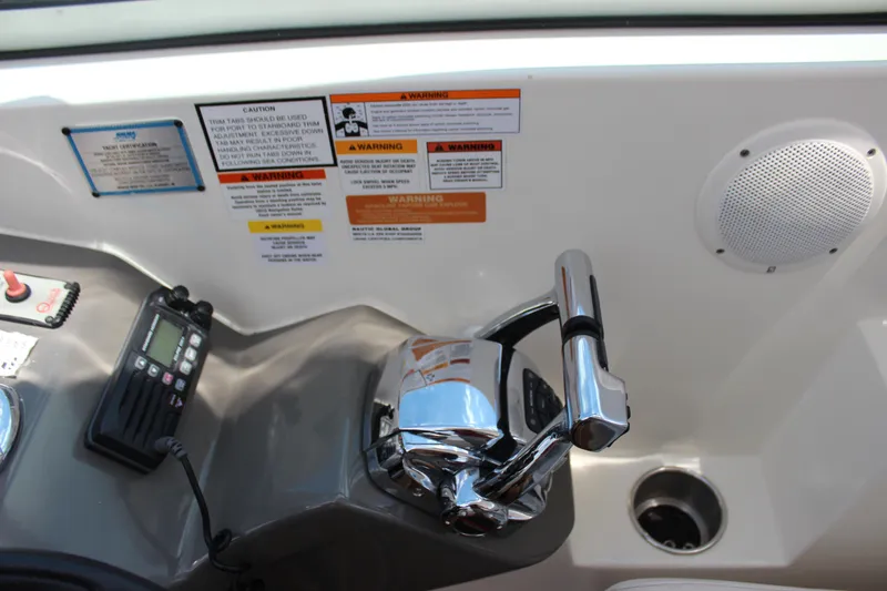 Slide: The Image of Control panel of a 2013 Rinker 31 boat with throttle and safety warnings. - 20