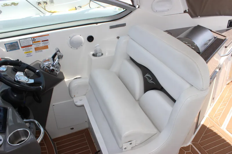 Slide: The Image of 2013 Rinker 31 boat cockpit with white leather seating and control panel. - 21