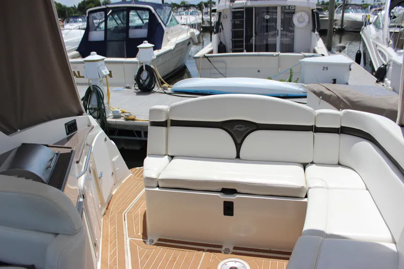 Slide: The Image of 2013 Rinker 31 boat with white seating at a marina. - 23