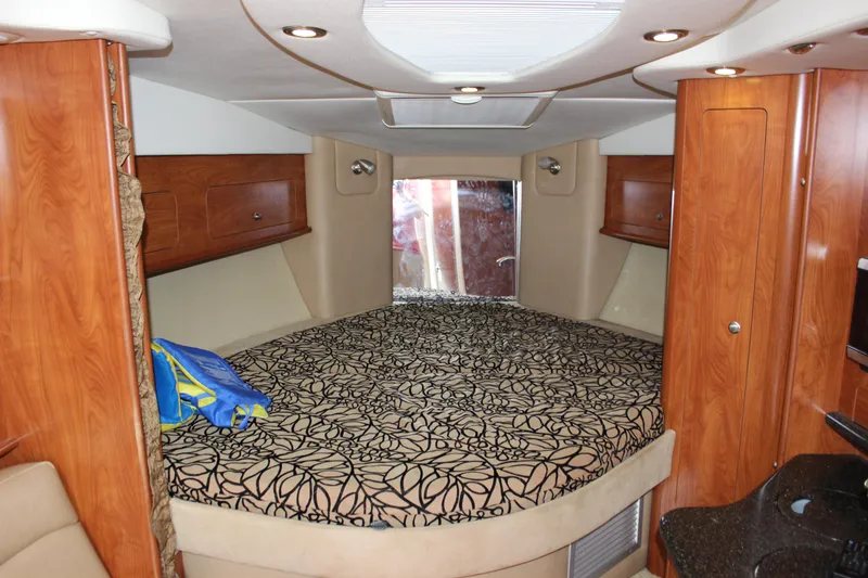 Slide: The Image of Interior cabin of 2013 Rinker 31 boat with bed and wooden cabinets. - 25