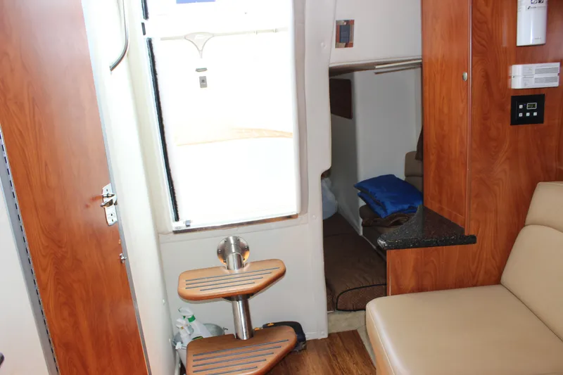 Slide: The Image of Interior of 2013 Rinker 31 boat with wooden finishes and beige seating. - 28