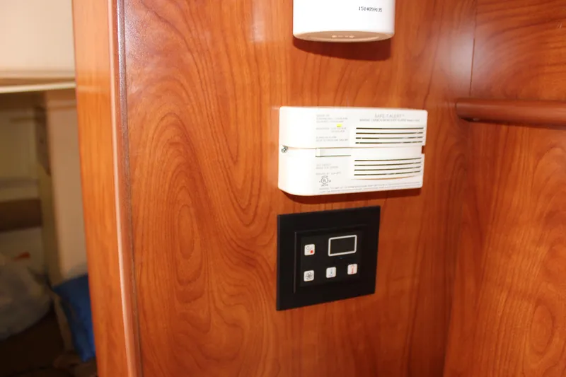 Slide: The Image of Control panel and smoke detector on wood paneling in 2013 Rinker 31 boat. - 31