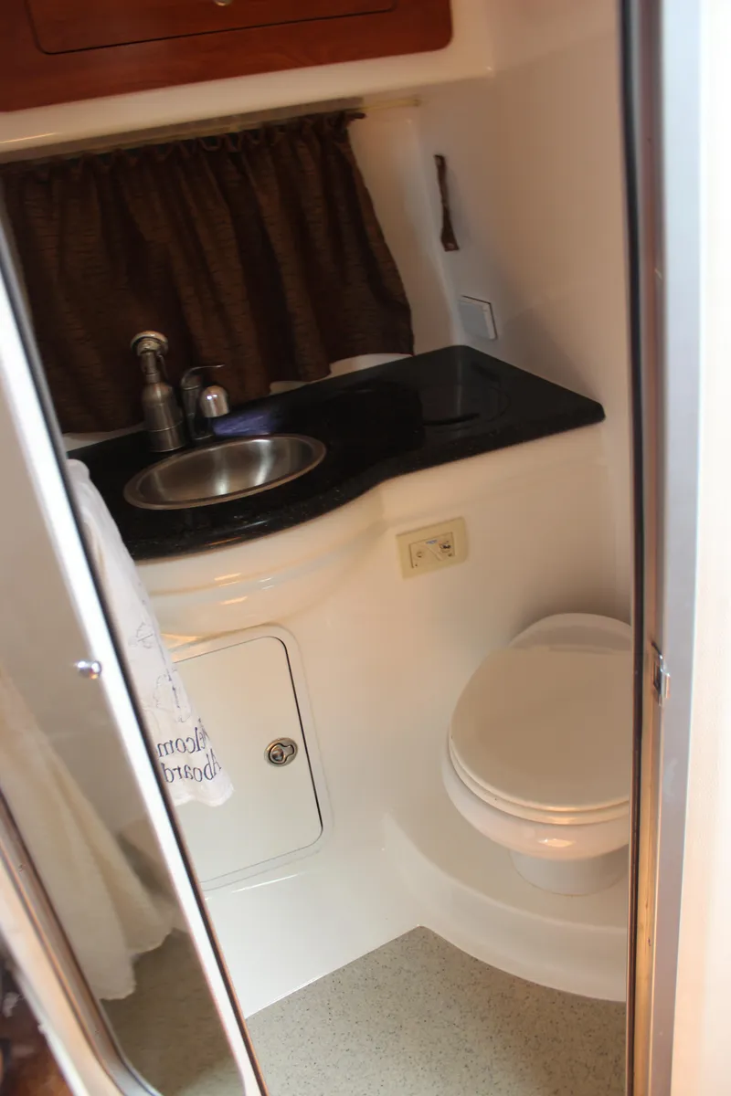 Slide: The Image of Compact bathroom in 2013 Rinker 31 boat with sink, toilet, and storage. - 33