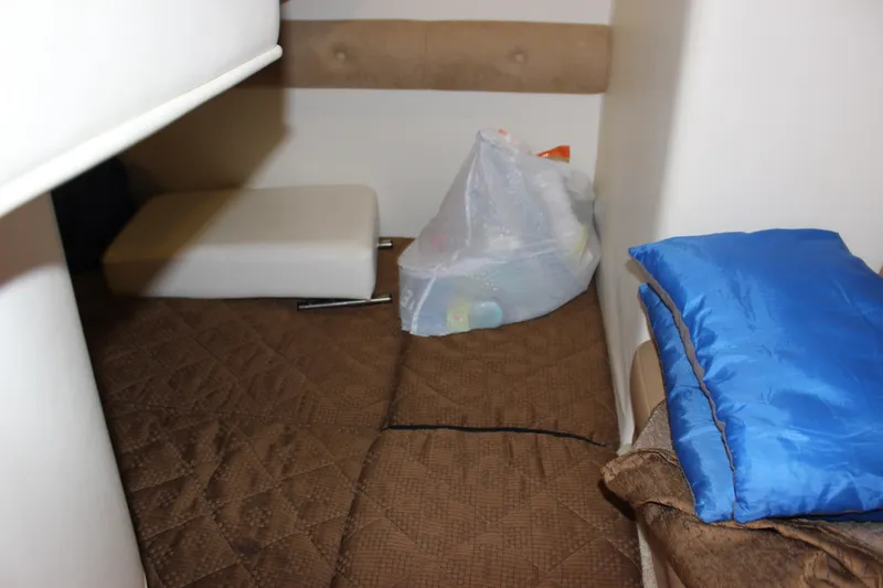 Slide: The Image of Interior cabin of a 2013 Rinker 31 boat with bedding and storage items. - 34