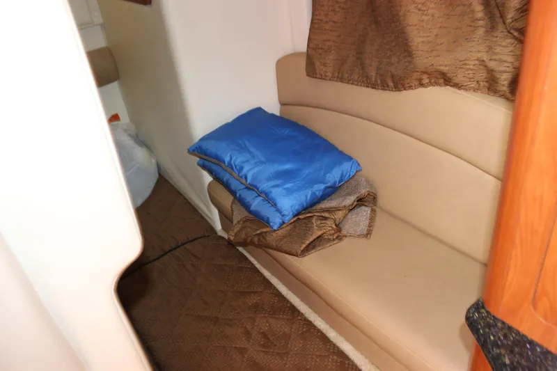 Slide: The Image of Interior of 2013 Rinker 31 boat with beige seating and blue blanket. - 36