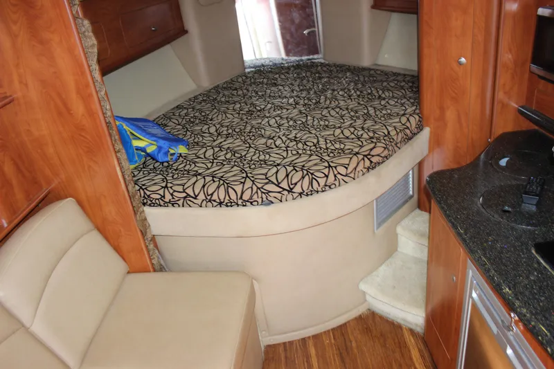 Slide: The Image of Interior cabin of 2013 Rinker 31 boat with bed, seating, and kitchenette. - 37