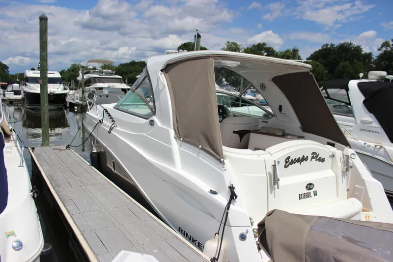 Slide: The Image of 2013 Rinker 31 boat docked at marina under clear skies. - 6