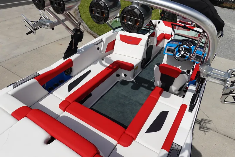 Slide: The Image of 2021 MasterCraft NXT22 boat interior with red and white seating, advanced audio system, and sleek design. - 15