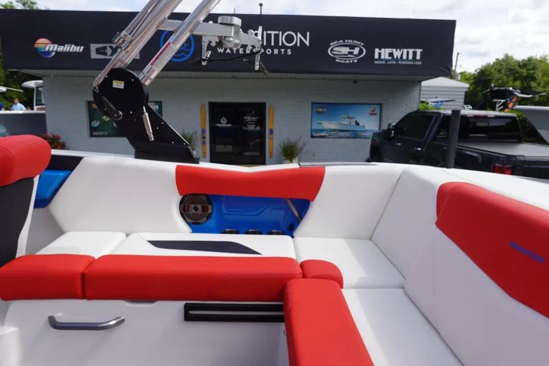 Slide: The Image of 2021 MasterCraft NXT22 boat interior with red and white seating at a dealership. - 20