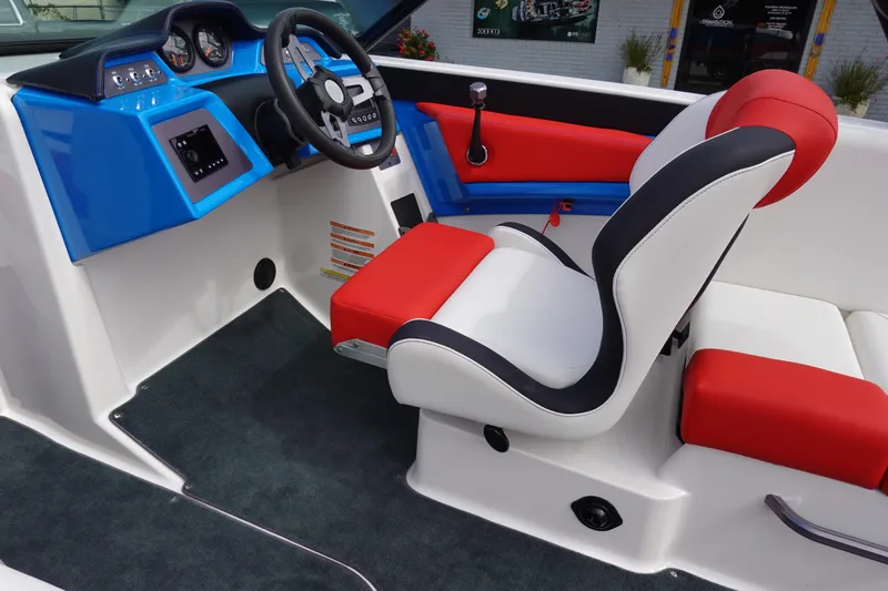 Slide: The Image of 2021 MasterCraft NXT22 boat interior with red, white, and blue seating and dashboard. - 22