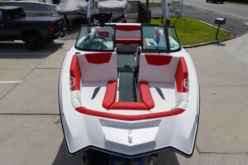 Slide: The Image of 2021 MasterCraft NXT22 boat with red and white interior, docked on a concrete surface. - 26