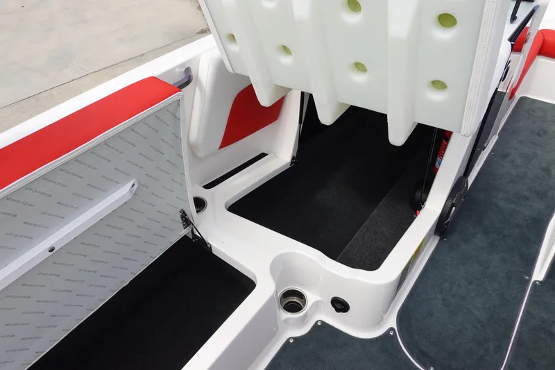 Slide: The Image of 2021 MasterCraft NXT22 boat interior with storage compartments and red accents. - 33