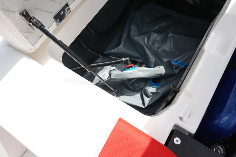 Slide: The Image of 2021 MasterCraft NXT22 storage compartment with hydraulic lift and gray cover. - 47