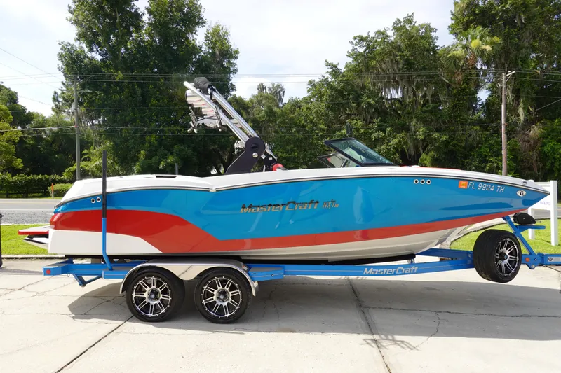 Slide: The Image of 2021 MasterCraft NXT22 boat on trailer, blue and red color scheme. - 5