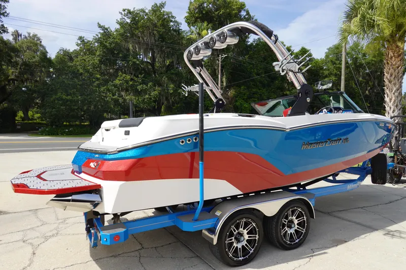 Slide: The Image of 2021 MasterCraft NXT22 boat on a trailer, blue and red color scheme. - 6