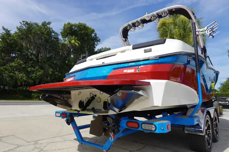 Slide: The Image of 2021 MasterCraft NXT22 boat on trailer, rear view, vibrant blue and red colors. - 8