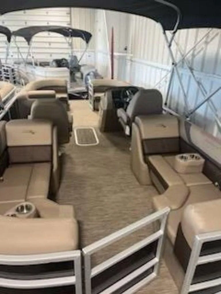 Slide: The Image of 2022 Bennington 22 SXSR SPS pontoon boat interior with beige seating and canopy. - 2